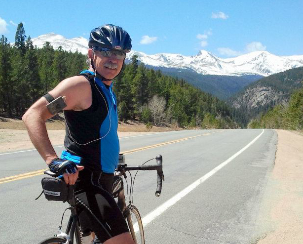 A Man Posing With His Bicycle On The Road