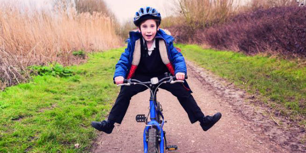 Image of A Happy and Charming Boy Riding A Bicycle.